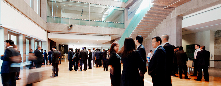 Inside Schulich building with people standing and networking