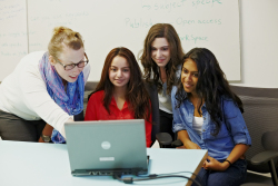Group of students and their instructor looking at a laptop screen.