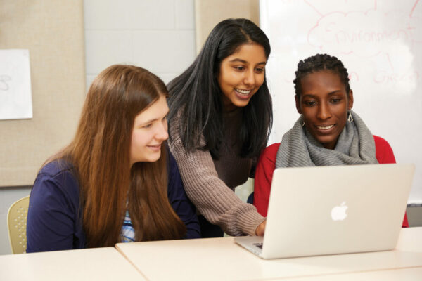 three students looking at laptop