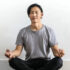 Photo of a man sitting on the floor while meditating
