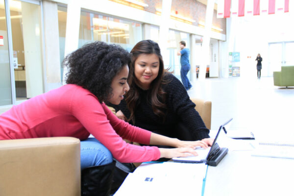 two people look at a computer screen together