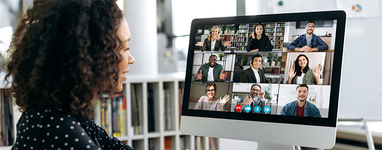 a woman views a virtual meeting on a computer screen