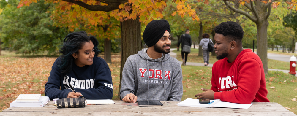 Students sitting on a picnic bench.