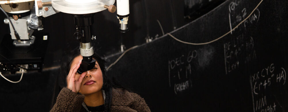 Female York University student looking through a telescope