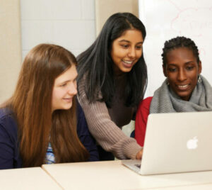 three students looking at laptop