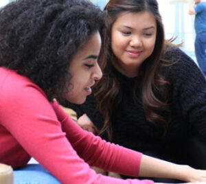 two students look at laptop