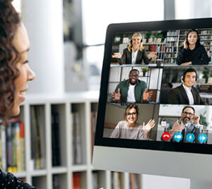 a woman views a virtual meeting on a computer screen